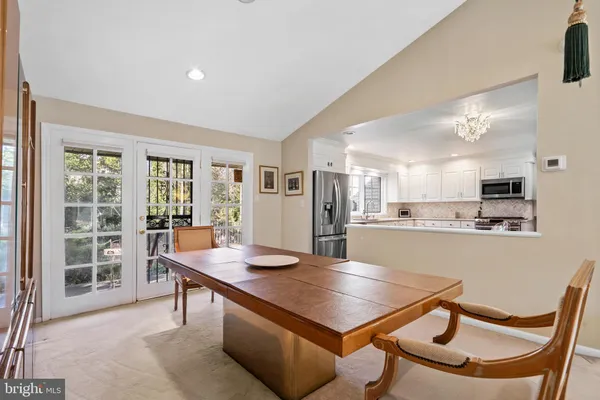 a room with stainless steel appliances kitchen island a table and chairs in it