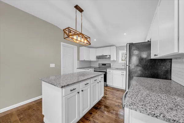 a kitchen with stainless steel appliances granite countertop a sink a stove a refrigerator and cabinets