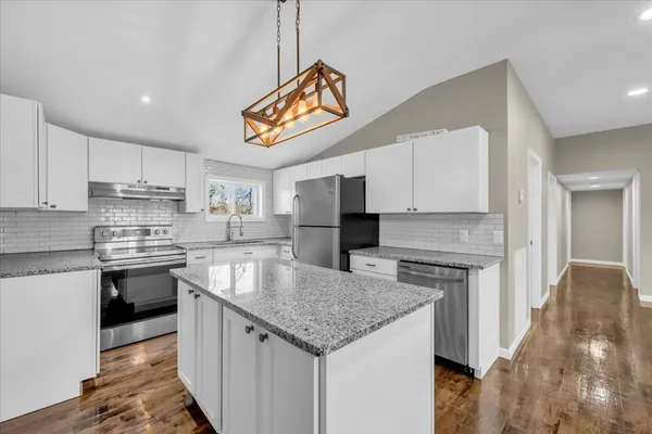 a kitchen with stainless steel appliances granite countertop a sink stove microwave and refrigerator
