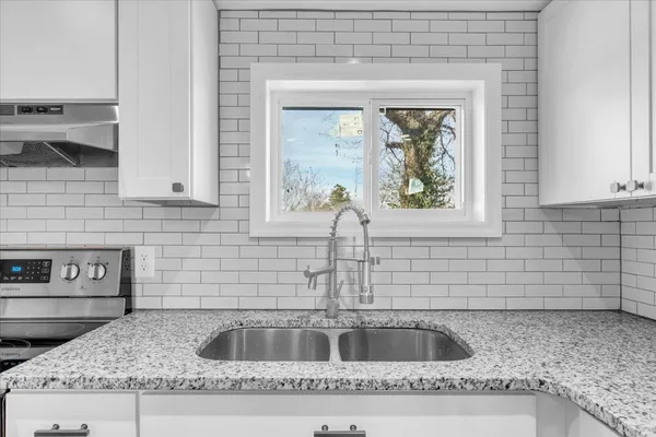a kitchen with granite countertop a sink and cabinets