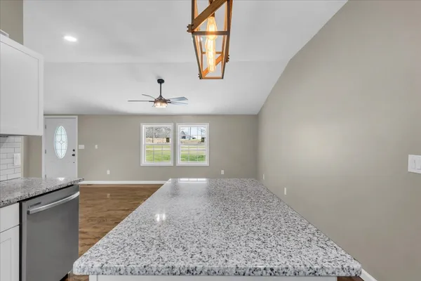 an empty room with windows and fireplace