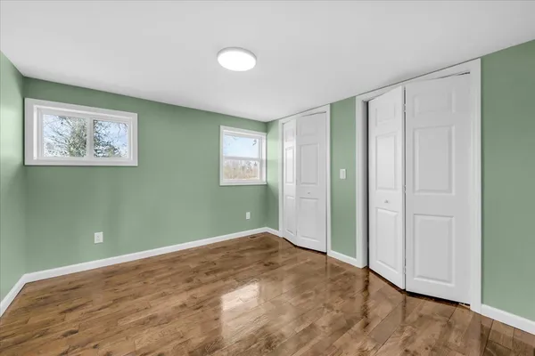 an empty room with closet and windows