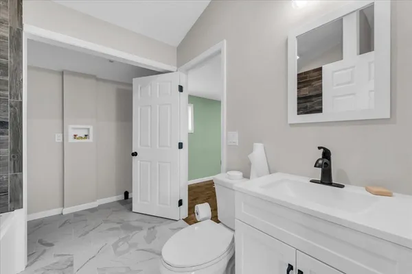 a bathroom with a sink a toilet and shower