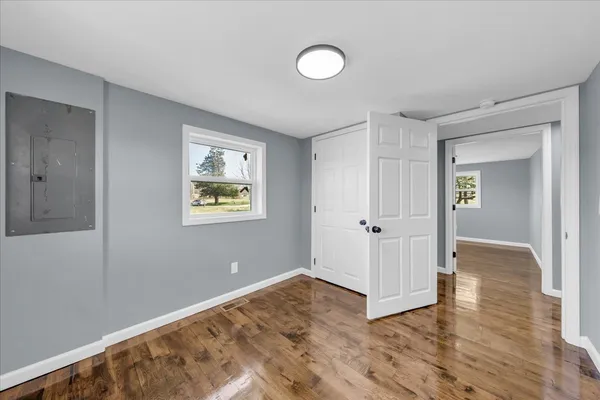 a view of an empty room with wooden floor