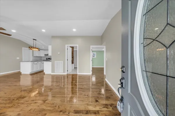 a view of a hallway with wooden floor and a living room