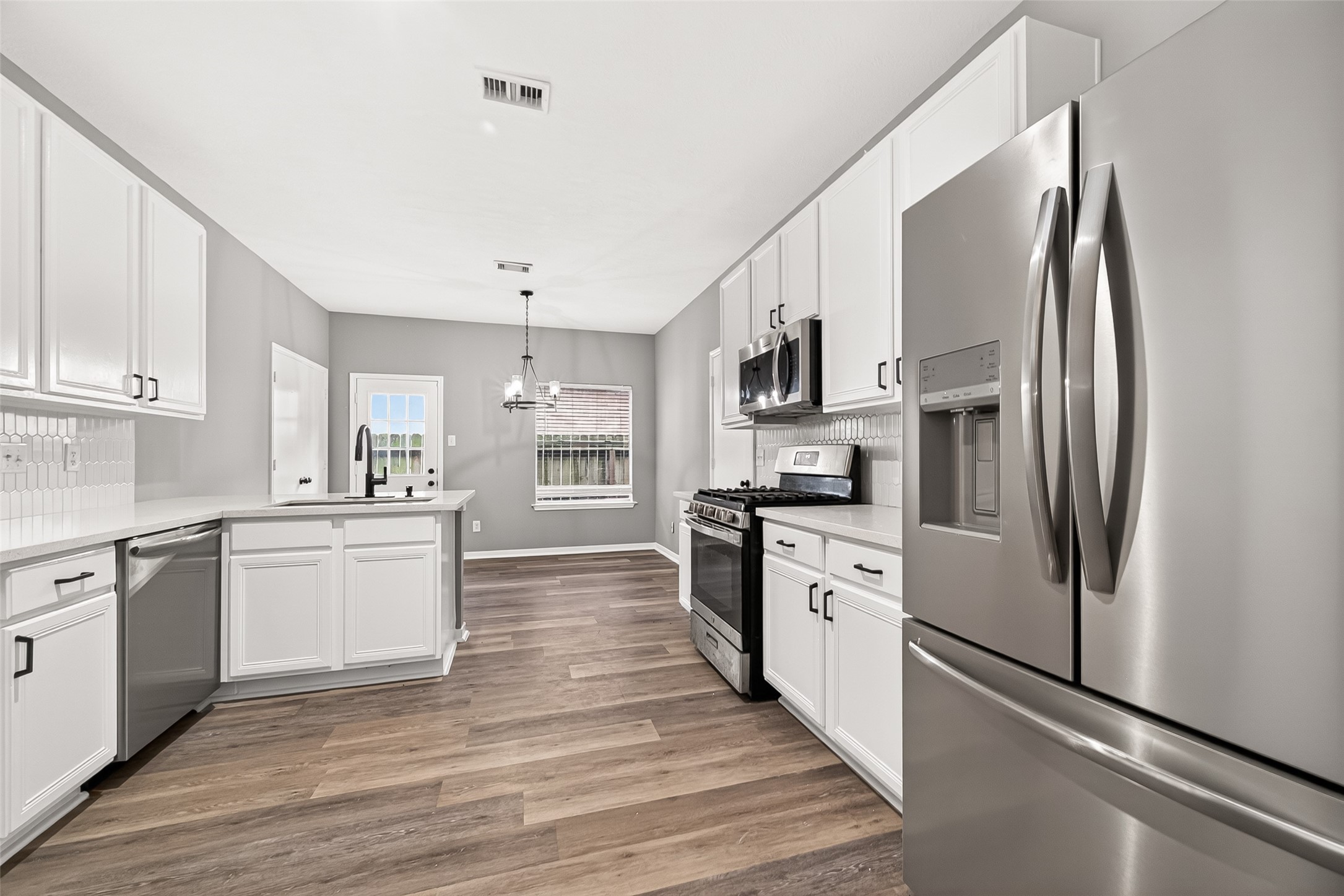 23810 Spring Way Drive Spring, TX 77373 - Photo 5 of 35 a kitchen with white cabinets and stainless steel appliances