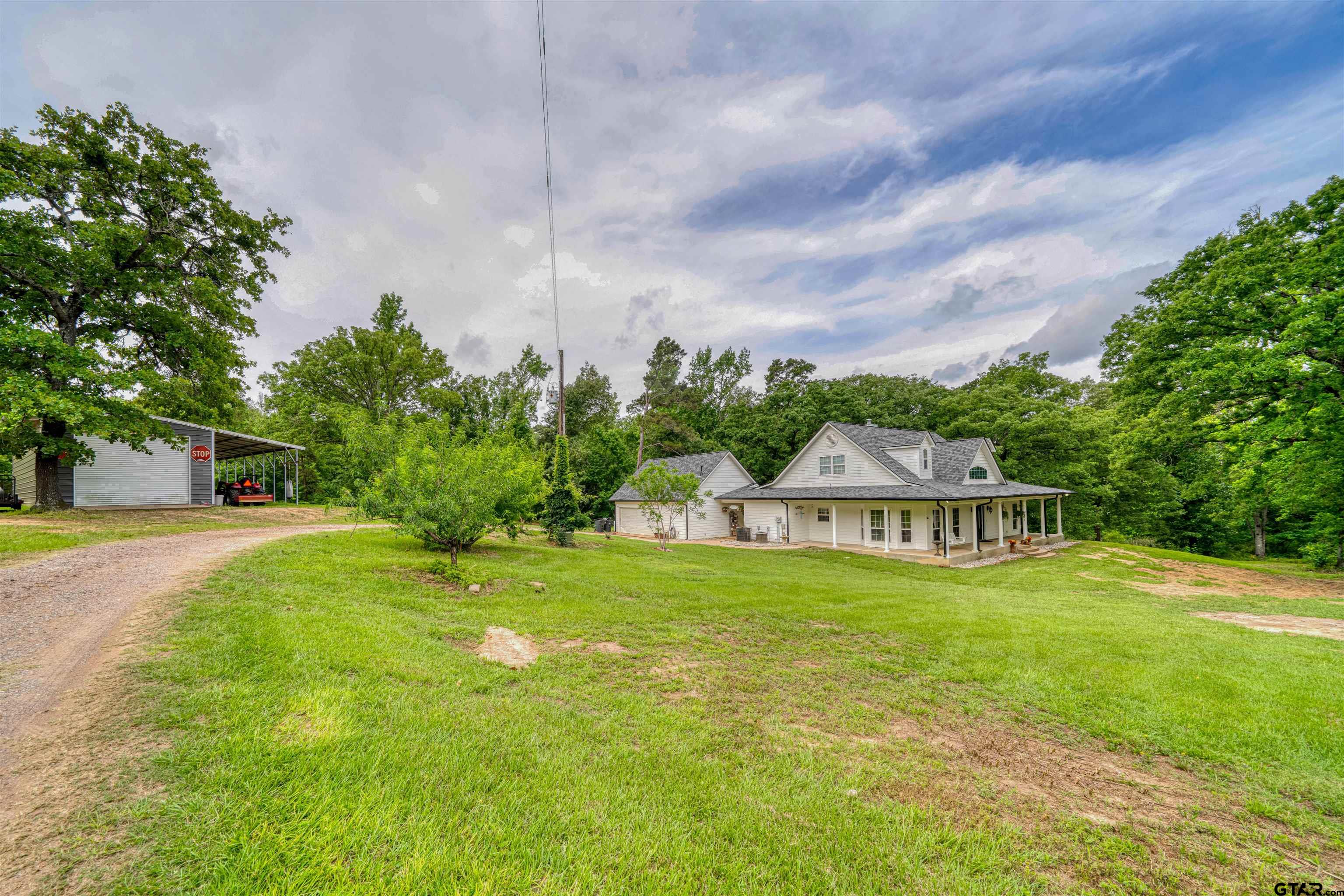 1776 Mustang Road Gilmer, TX 75645 - Photo 2 of 45 a view of a house with a big yard and large trees