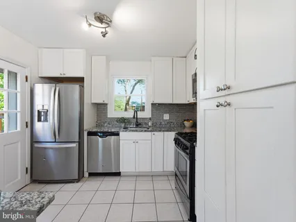 a kitchen with stainless steel appliances granite countertop a refrigerator and a stove top oven