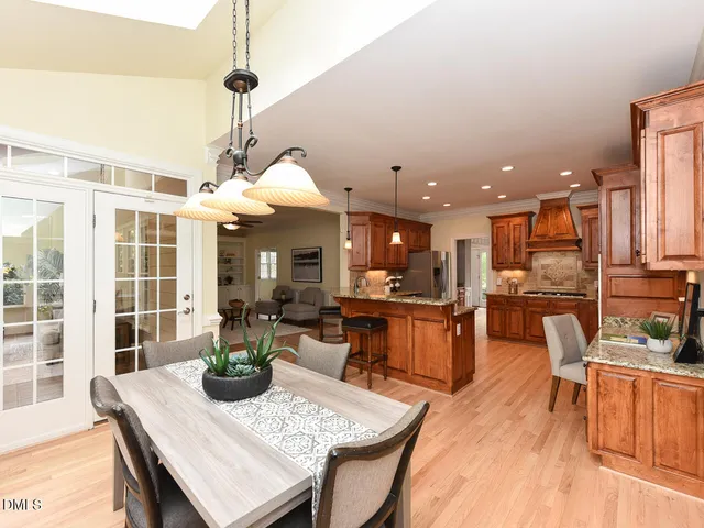 a view of a dining room and livingroom with furniture wooden floor a chandelier