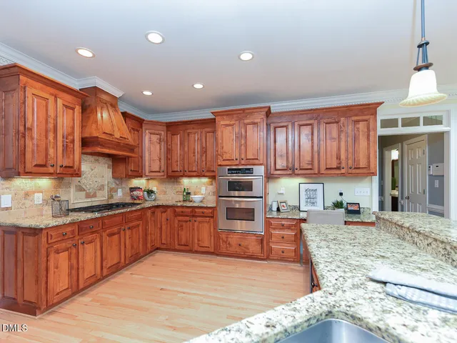 a kitchen with stainless steel appliances granite countertop a stove sink and cabinets