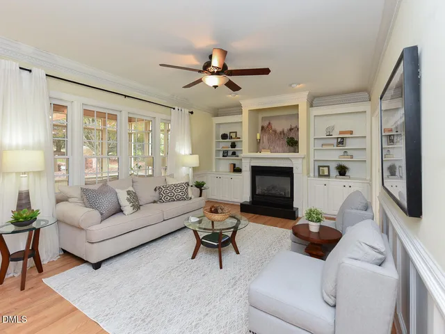 a living room with furniture a flat screen tv and a fireplace