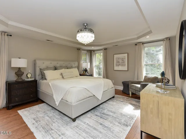 a bedroom with a large bed and a chandelier