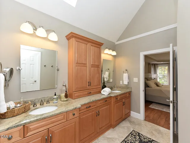 a spacious bathroom with a granite countertop sink mirror and a shower