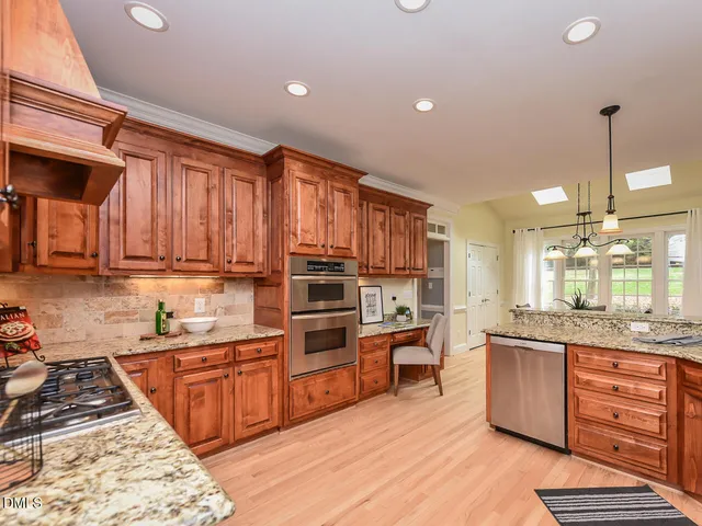 a kitchen with stainless steel appliances granite countertop a stove a sink and a refrigerator