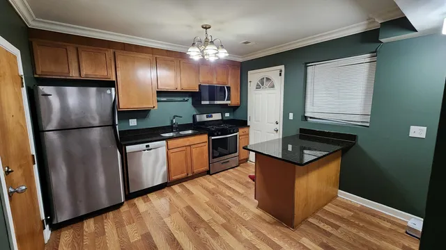 a kitchen with granite countertop a refrigerator a sink dishwasher stove and oven