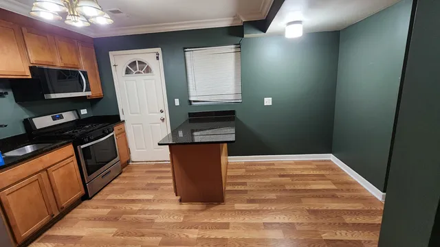 a kitchen with granite countertop cabinets and black appliances