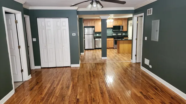 a view of a hallway view with wooden floor and a kitchen space