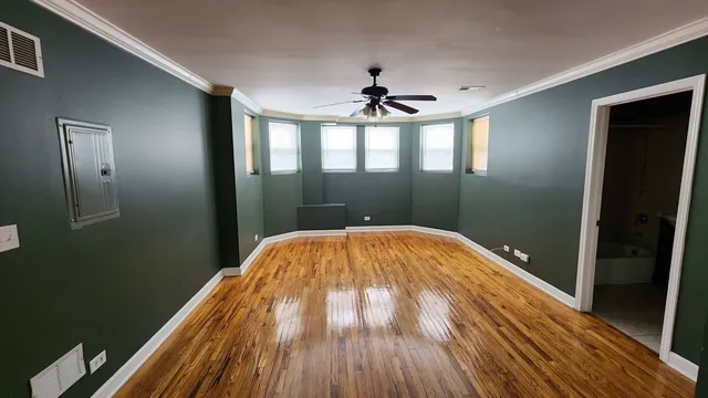 a view of empty room with wooden floor