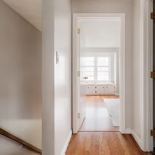 a view of a room with wooden floor and a sink