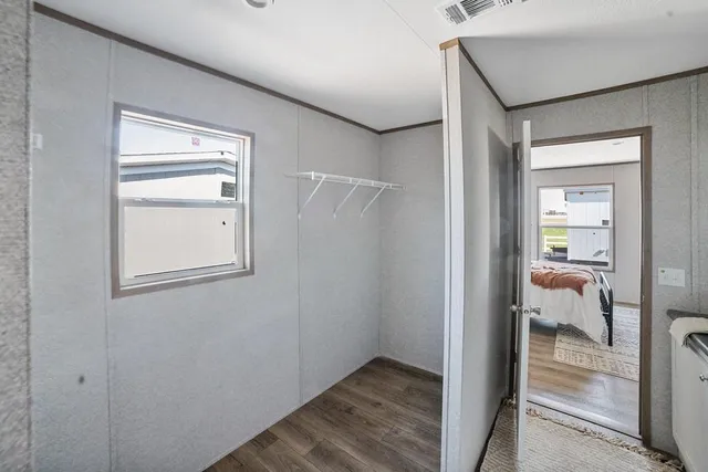 a view of a hallway with a room that has a bed