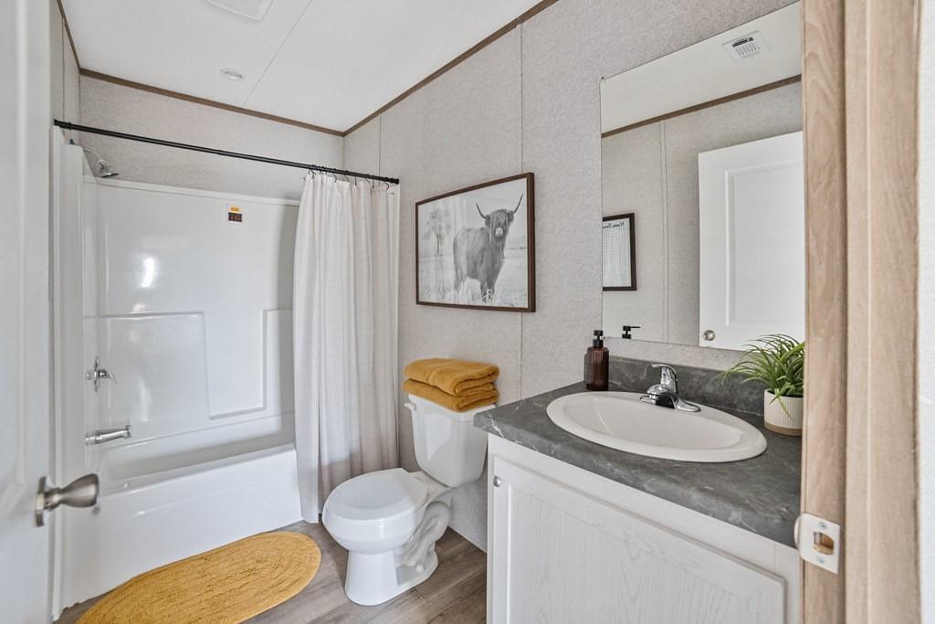 4127 Denver Road Sunset, TX 76270 - Photo 32 of 34 a bathroom with a granite countertop sink toilet and shower