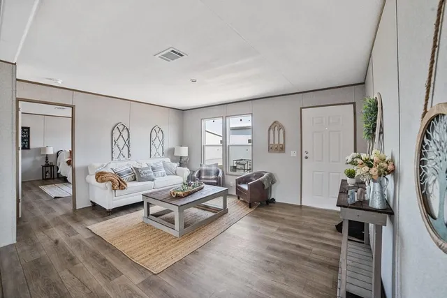 a living room with furniture potted plant and a large window