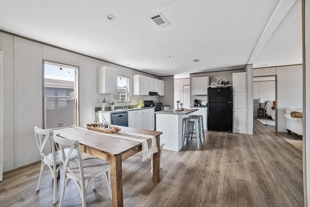 a kitchen with a dining table chairs refrigerator and cabinets