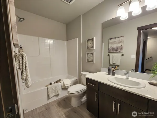 a bathroom with a double vanity sink toilet mirror and shower