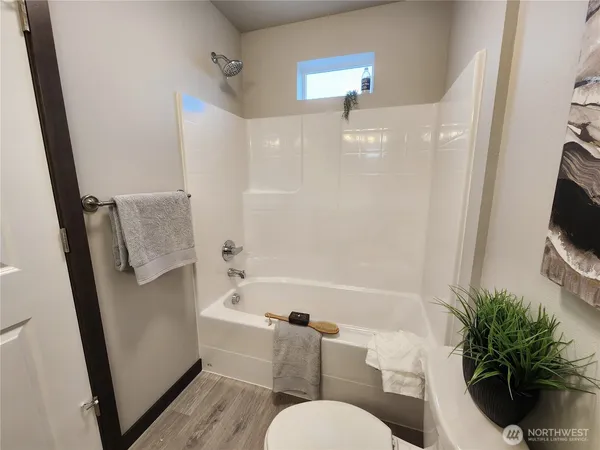 a bathroom with a sink a toilet a tub and a mirror