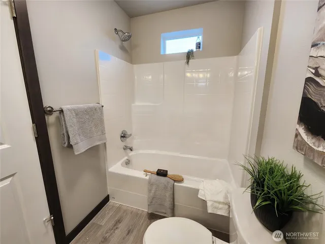 a bathroom with a sink a toilet a tub and a mirror