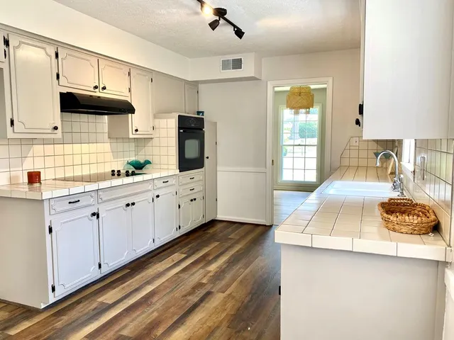 a kitchen with stainless steel appliances a sink stove and cabinets