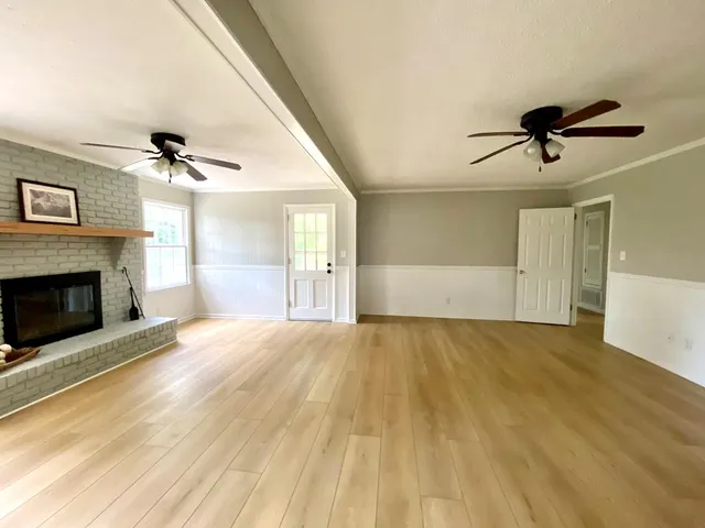a view of empty room with a fireplace and wooden floor