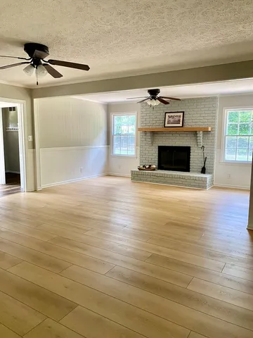a view of an empty room with a fireplace and a window