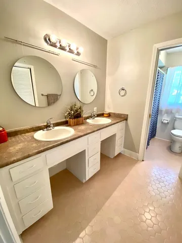 a bathroom with a double vanity sink and a mirror