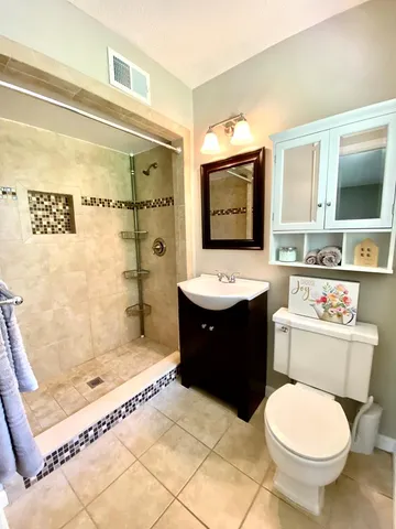 a bathroom with a toilet sink shower and mirror