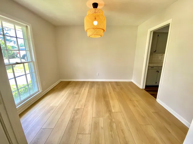 a view of a room with wooden floor and windows