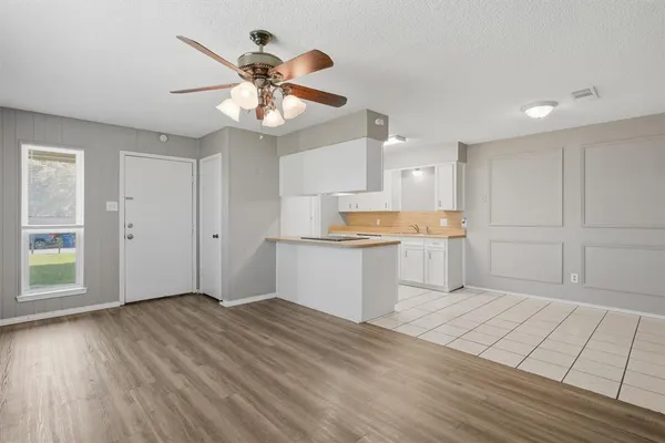 a view of an empty room and window and wooden floor