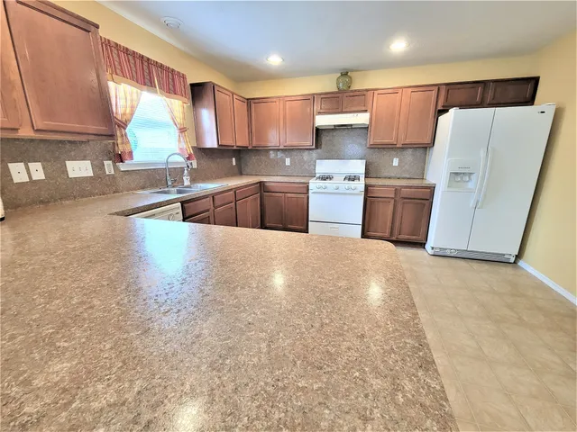 a kitchen with stainless steel appliances a refrigerator a sink a stove a microwave and cabinets