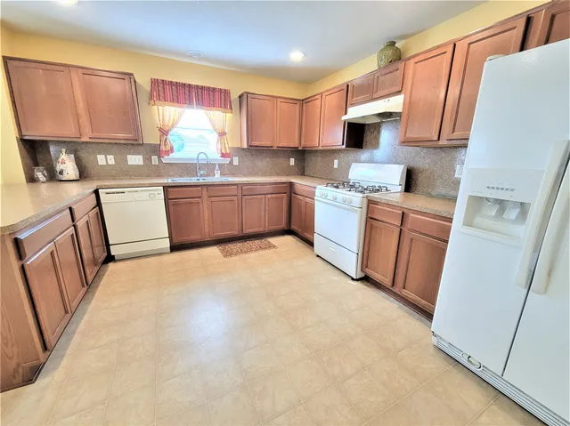a kitchen with stainless steel appliances a refrigerator sink stove microwave and cabinets