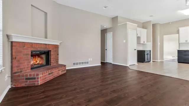 a living room with wooden floors and a fireplace