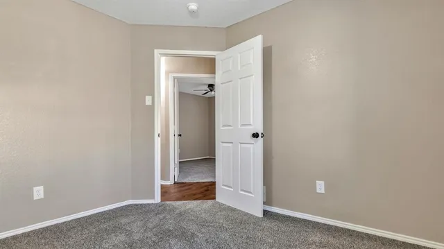 an empty room with closet and mirror