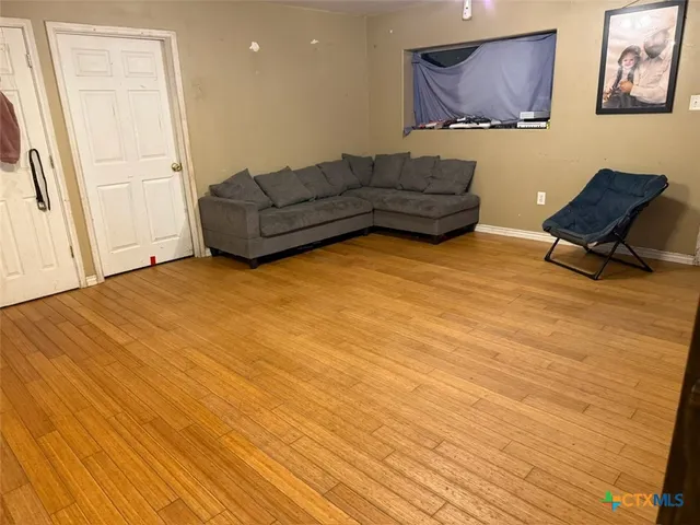 a living room with furniture and a wooden floor