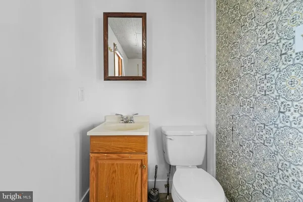 a bathroom with a toilet a sink and mirror