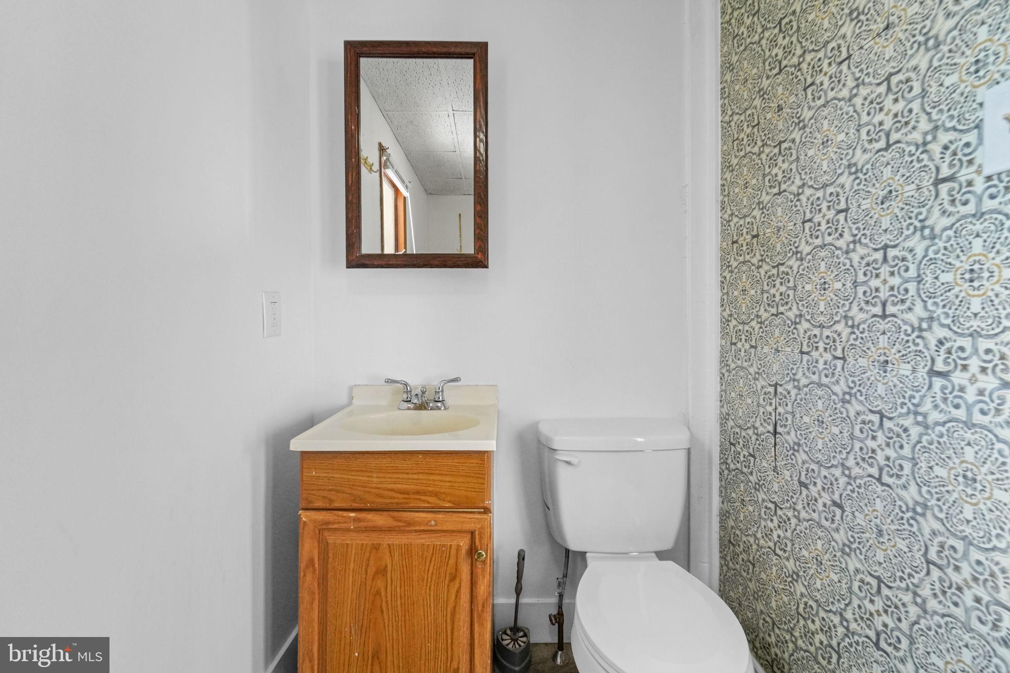 200 Union Street Salem, NJ 08079 - Photo 11 of 43 a bathroom with a toilet a sink and mirror