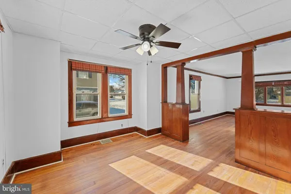 a view of an empty room with window and wooden floor
