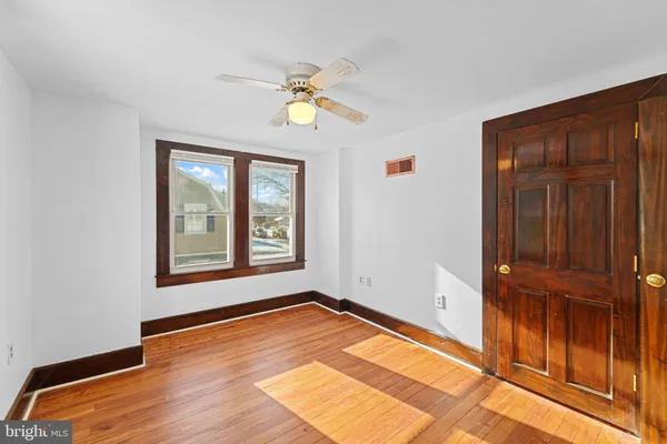 a view of an empty room with window and wooden floor