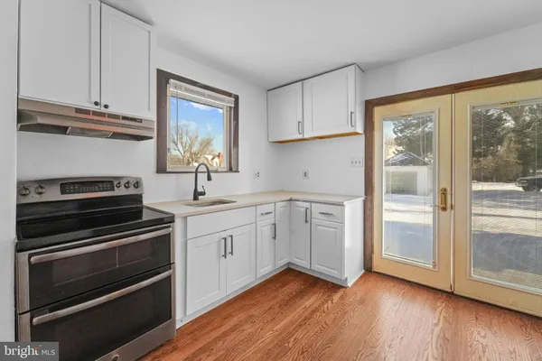 a kitchen with appliances cabinets and a wooden floor