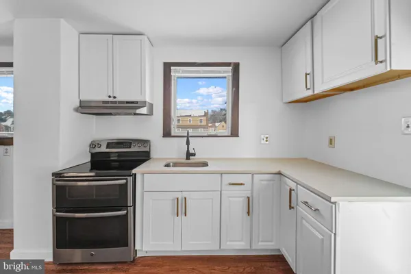 a kitchen with white cabinets and appliances