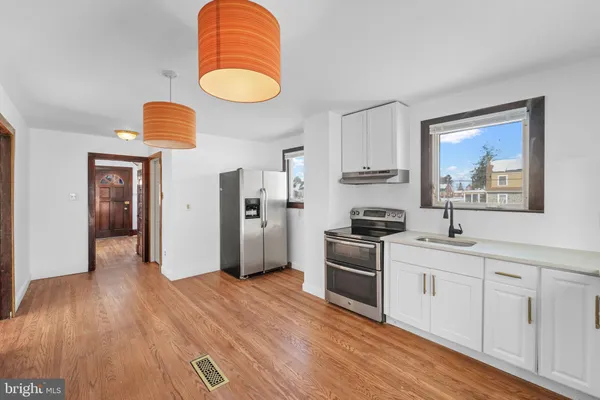 a kitchen with stainless steel appliances granite countertop a stove and a wooden floors