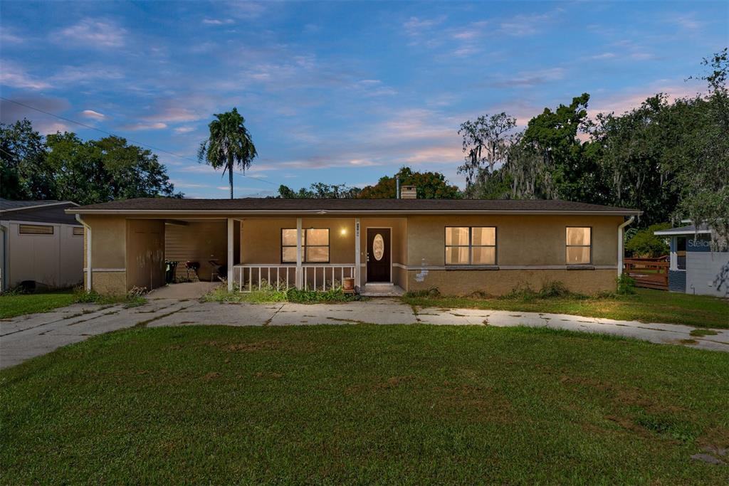 a backyard of a house with table and chairs and wooden fence